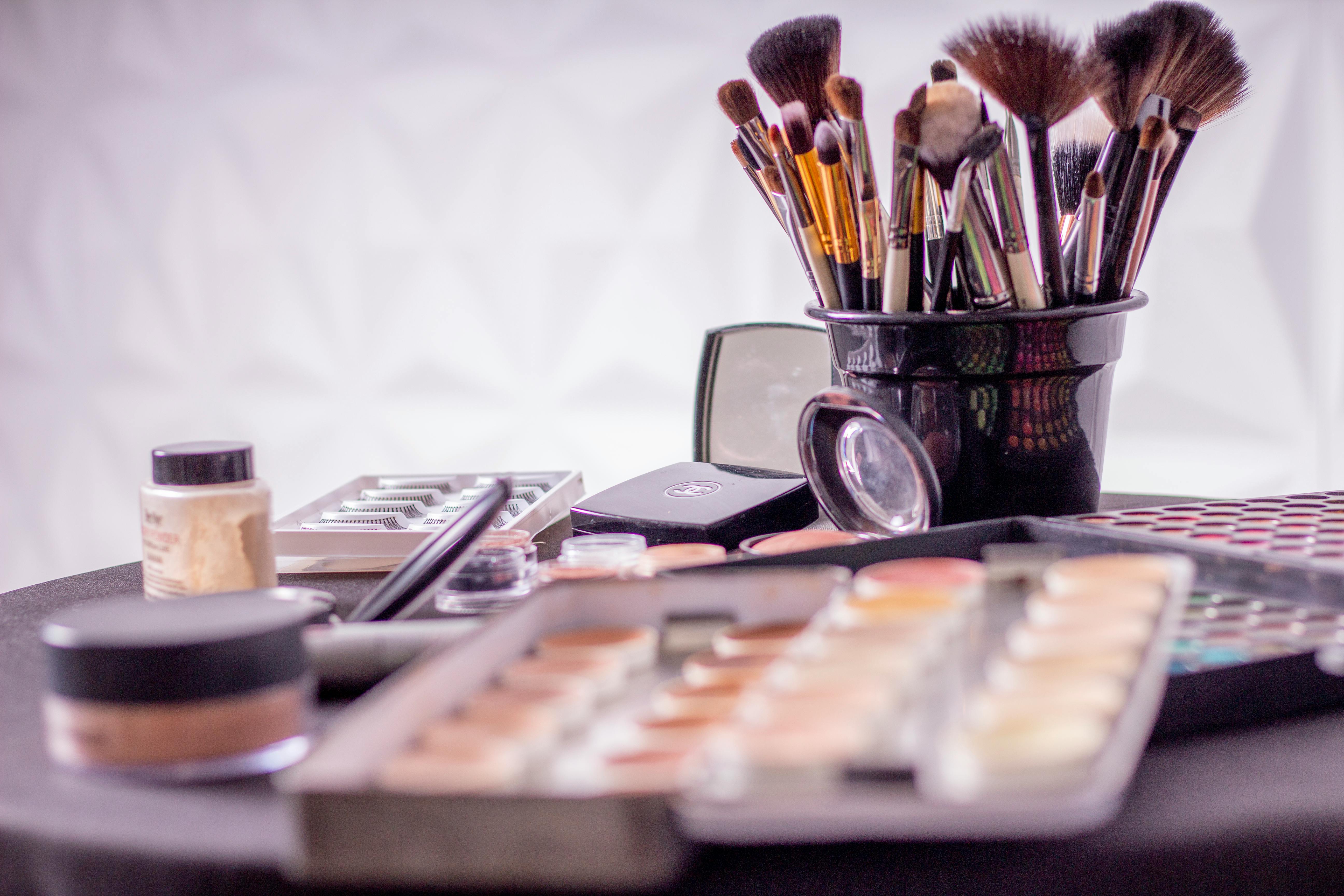 A collection of makeup paraphernalia on a small table.